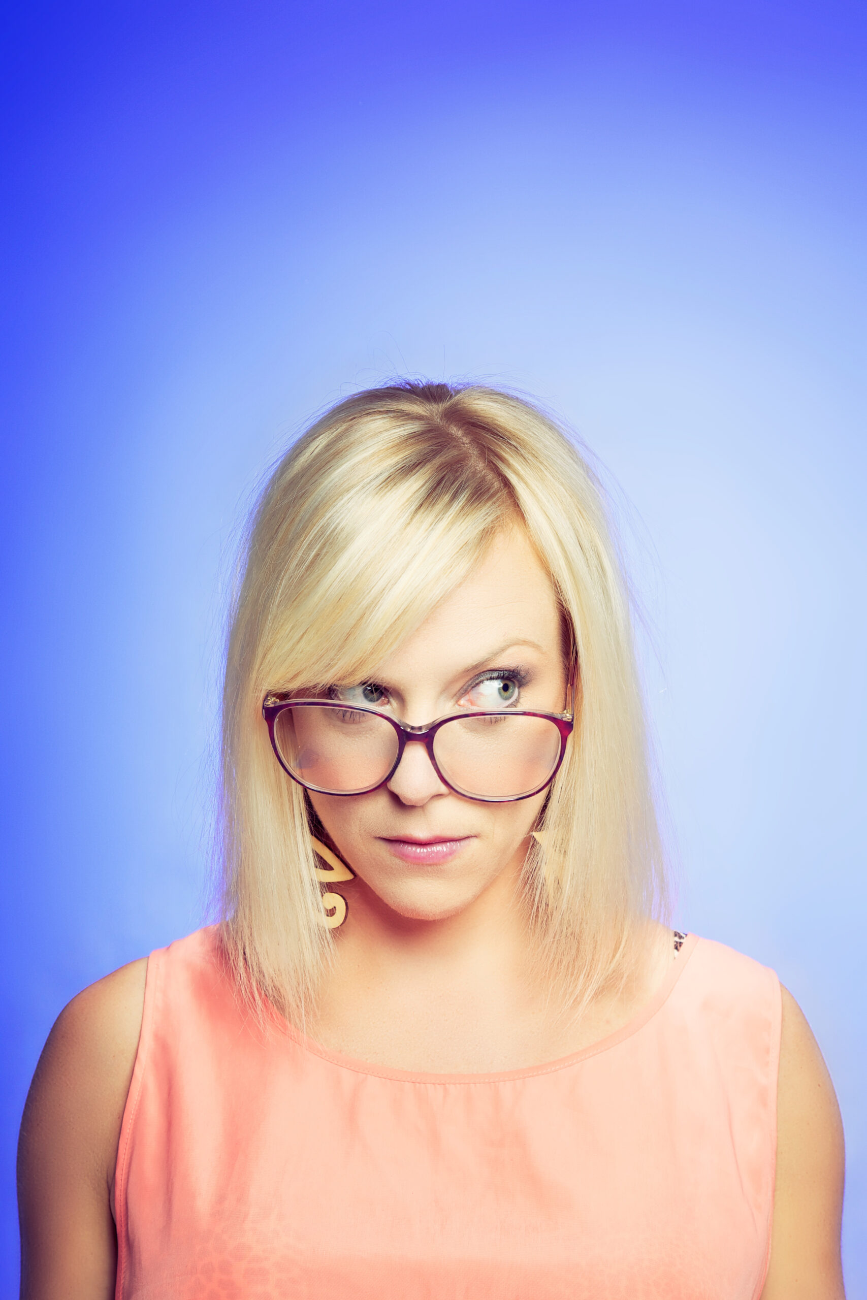 Portrait of a young skeptical woman isolated over blue background